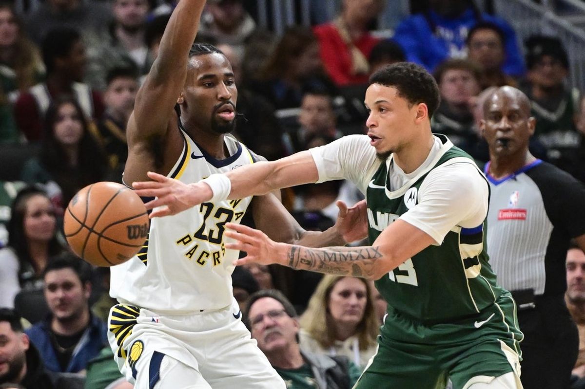 Feb 6, 2026; Milwaukee, Wisconsin, USA;  Milwaukee Bucks guard Ryan Rollins (13) passes the ball away from Indiana Pacers forward Aaron Nesmith (23) in the second quarter at Fiserv Forum. Mandatory Credit: Benny Sieu-Imagn Images
