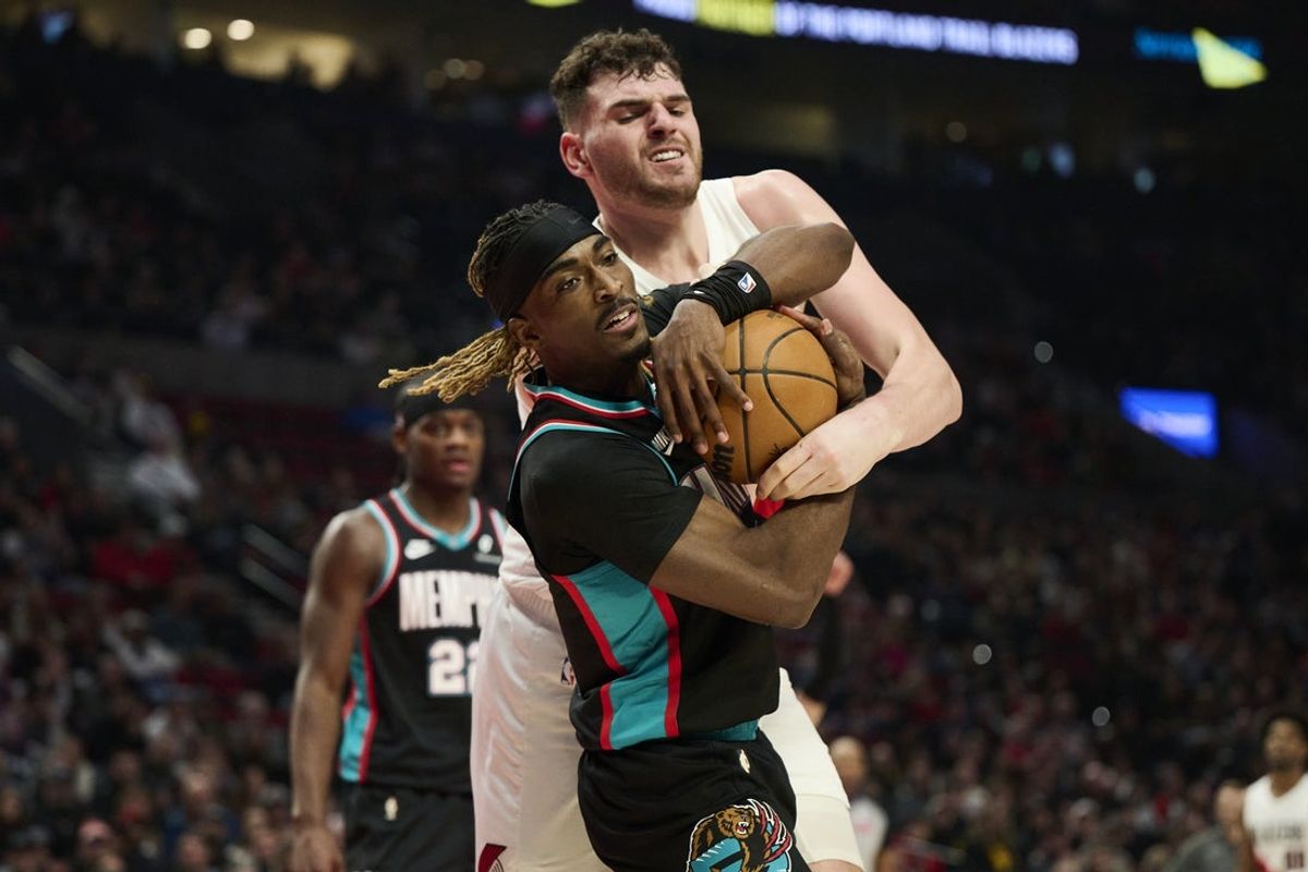 Feb 6, 2026; Portland, Oregon, USA; Memphis Grizzlies guard Jahmai Mashack (21) and Portland Trail Blazers center Donovan Clingan (23) struggle for control of a loose ball during the first half at Moda Center. Mandatory Credit: Troy Wayrynen-Imagn Images