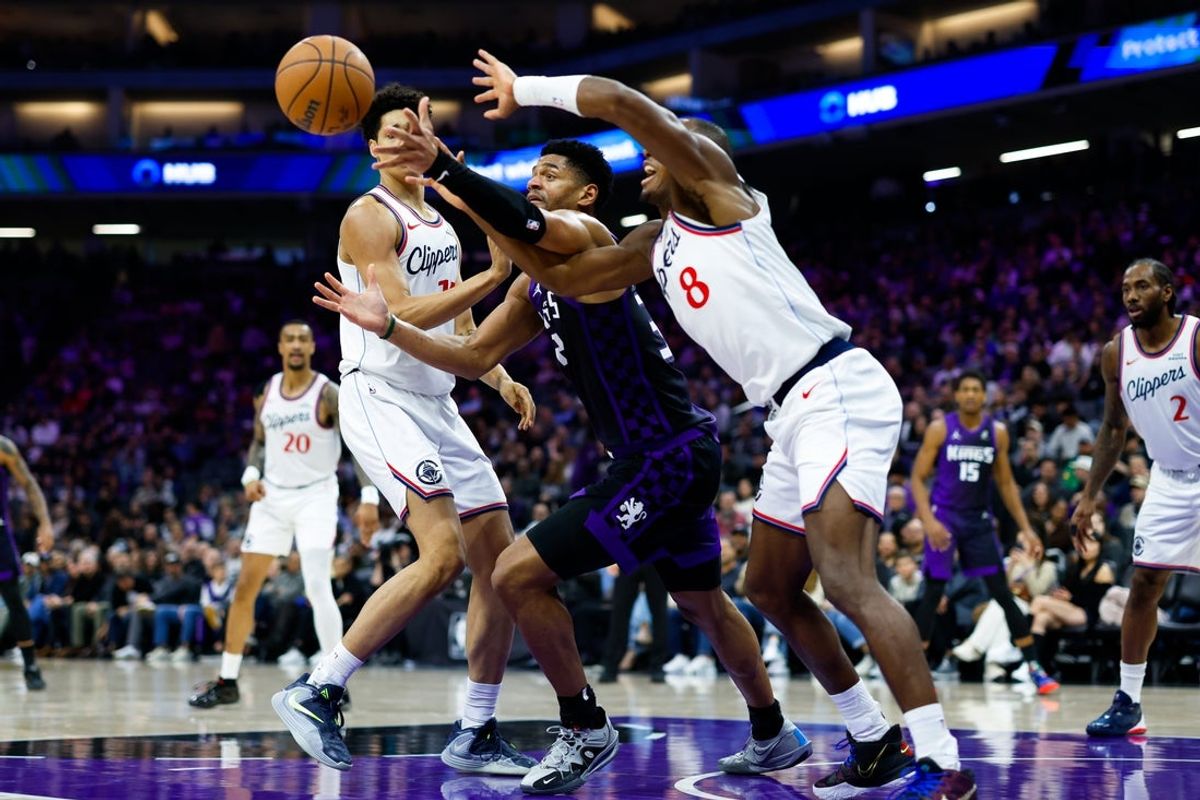 Feb 6, 2026; Sacramento, California, USA; Sacramento Kings center Dylan Cardwell (32) and Los Angeles Clippers guard Kris Dunn (8) reach for the ball during the second quarter at Golden 1 Center. Mandatory Credit: Sergio Estrada-Imagn Images