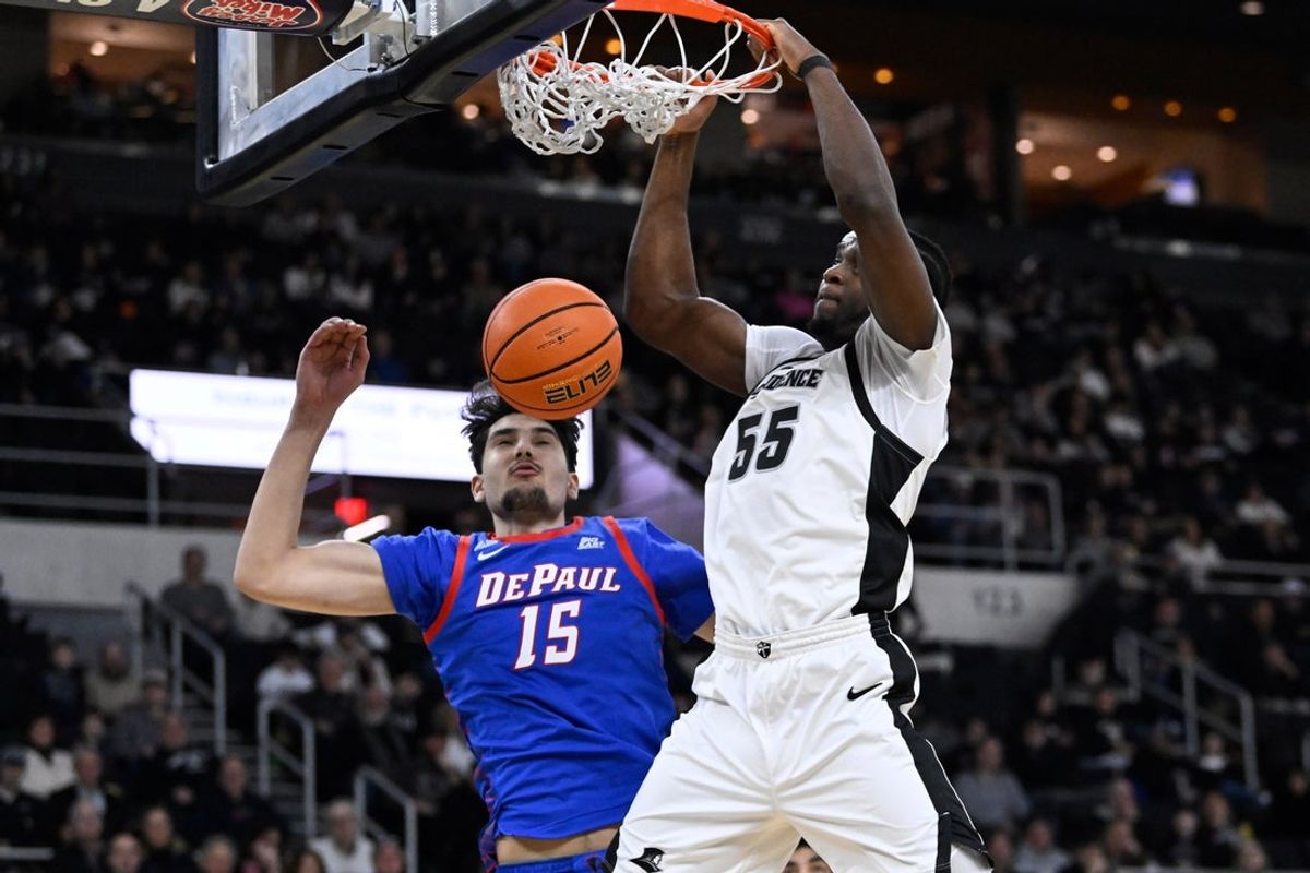Feb 7, 2026; Providence, Rhode Island, USA; Providence Friars forward Oswin Erhunmwunse (55) dunks the ball against DePaul Blue Demons center Fabian Flores (15) during the first half at Amica Mutual Pavilion. Mandatory Credit: Eric Canha-Imagn Images