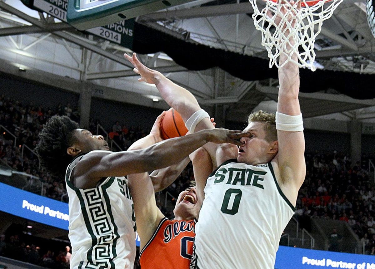 Feb 7, 2026; East Lansing, Michigan, USA;  Michigan State Spartans guard Trey Fort (9) stops teammate Michigan State Spartans forward Jaxon Kohler (0) while the pair defend Illinois Fighting Illini forward David Mirkovic (0) during the first half at Jack Breslin Student Events Center. Mandatory Credit: Dale Young-Imagn Images