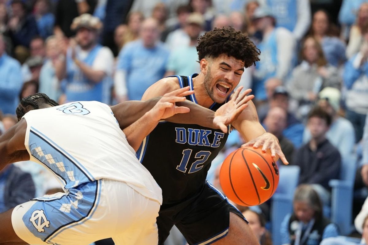 Feb 7, 2026; Chapel Hill, North Carolina, USA;  North Carolina Tar Heels forward Caleb Wilson (8) and Duke Blue Devils forward Cameron Boozer (12) fight for the ball in the first  half at Dean E. Smith Center. Mandatory Credit: Bob Donnan-Imagn Images