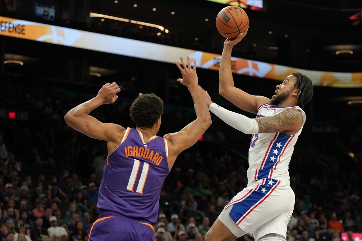 Feb 7, 2026; Phoenix, Arizona, USA; Philadelphia 76ers forward Trendon Watford (12) shoots over Phoenix Suns forward Oso Ighodaro (11) during the second half of an NBA game at Mortgage Matchup Center. Mandatory Credit: Rick Scuteri-Imagn Images