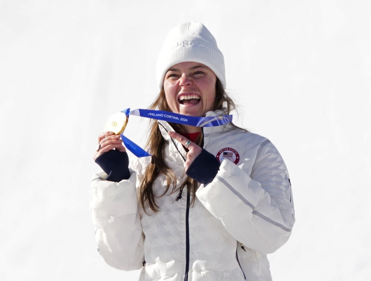 Feb 8, 2026; Cortina d'Ampezzo, Italy; Breezy Johnson of the United States celebrates with her gold medal after winning the women's downhill alpine skiing race during the Milano Cortina 2026 Olympic Winter Games at Tofane Alpine Skiing Centre. Mandatory Credit: Michael Madrid-Imagn Images