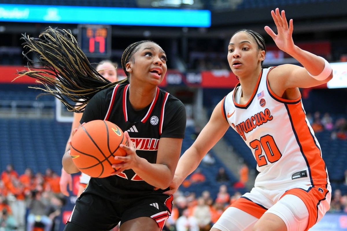 Feb 8, 2026; Syracuse, New York, USA; Louisville Cardinals guard Tajianna Roberts (22) drives against Syracuse Orange guard Dominique Darius (20) during the second half at the JMA Wireless Dome. Mandatory Credit: Rich Barnes-Imagn Images
