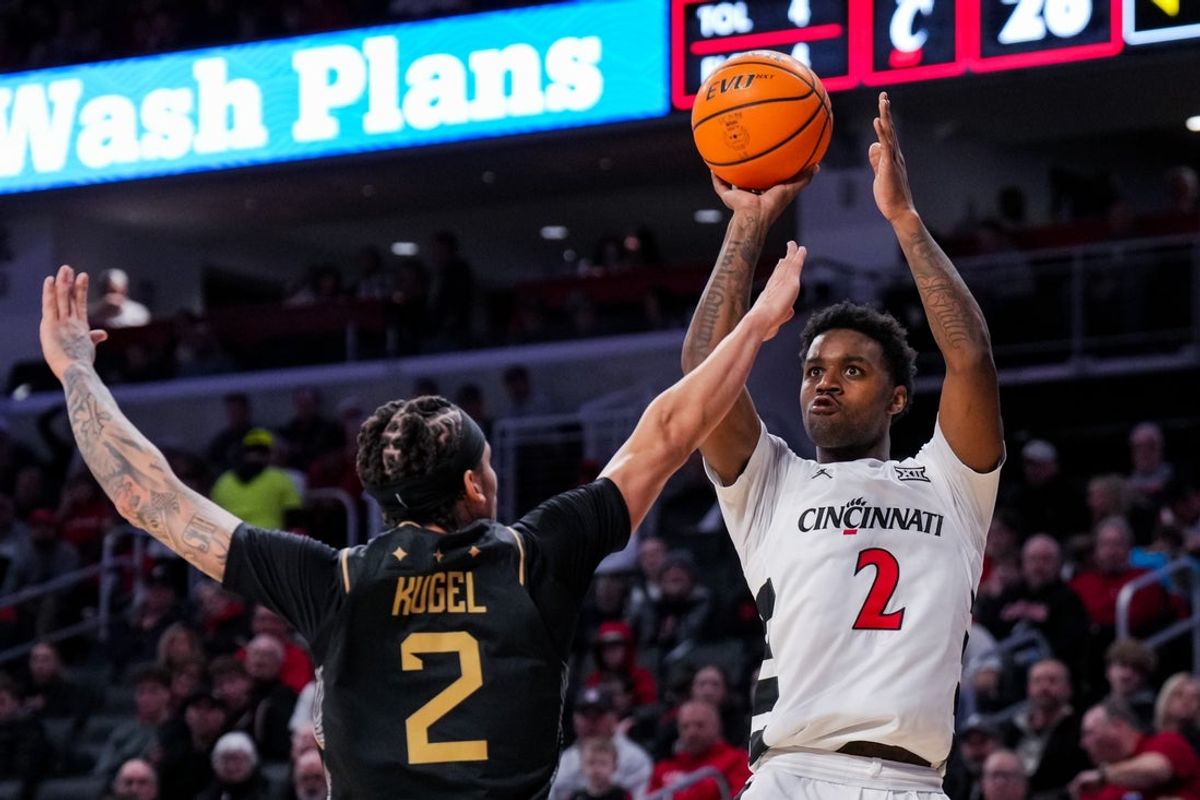 Feb 8, 2026; Cincinnati, Ohio, USA;  Cincinnati Bearcats guard Jizzle James (2) shoots against UCF Knights guard Riley Kugel (2) in the first half at Fifth Third Arena. Mandatory Credit: Aaron Doster-Imagn Images
