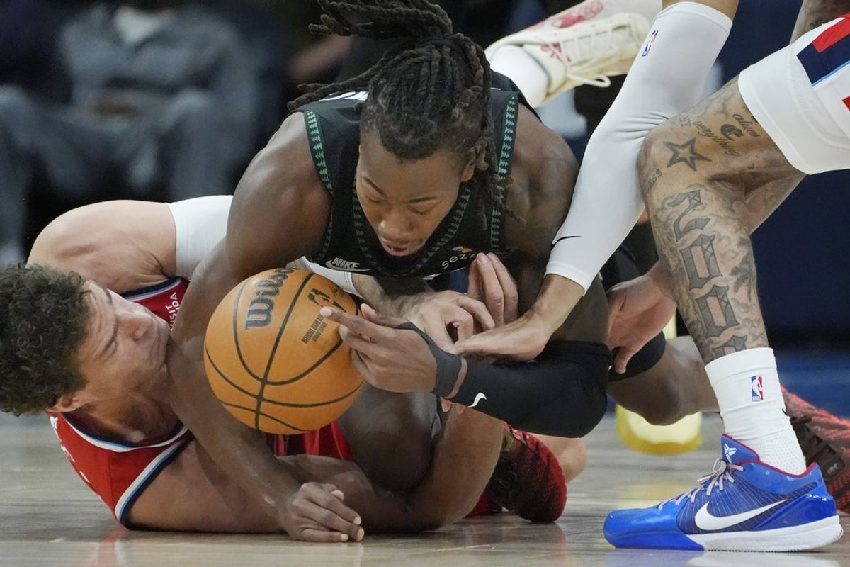 Feb 8, 2026; Minneapolis, Minnesota, USA; Minnesota Timberwolves guard Ayo Dosunmu (13) battles Los Angeles Clippers center Brook Lopez (11) for the ball in the first quarter at Target Center. Mandatory Credit: Bruce Kluckhohn-Imagn Images