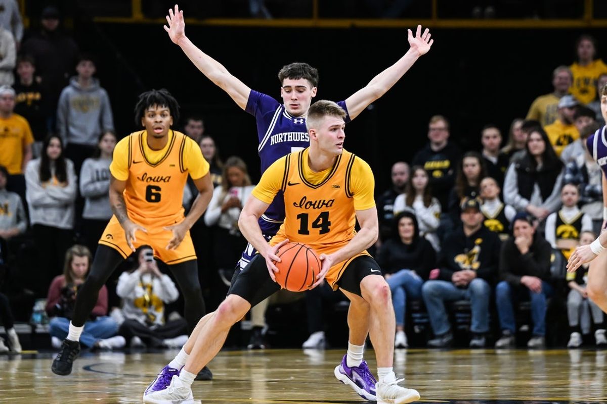 Feb 8, 2026; Iowa City, Iowa, USA; Iowa Hawkeyes guard Bennett Stirtz (14) is defended by Northwestern Wildcats guard Jake West (3) during the first half at Carver-Hawkeye Arena. Mandatory Credit: Jeffrey Becker-Imagn Images