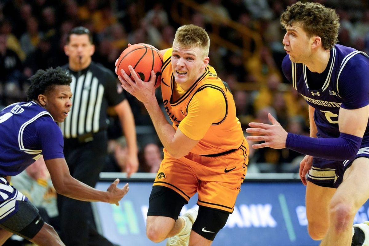 Iowa guard Bennett Stirtz (14) drives toward the basket against Northwestern guard Jayden Reid (4) and Northwestern forward Nick Martinelli (2) Feb. 8, 2026 at Carver-Hawkeye Arena in Iowa City, Iowa.