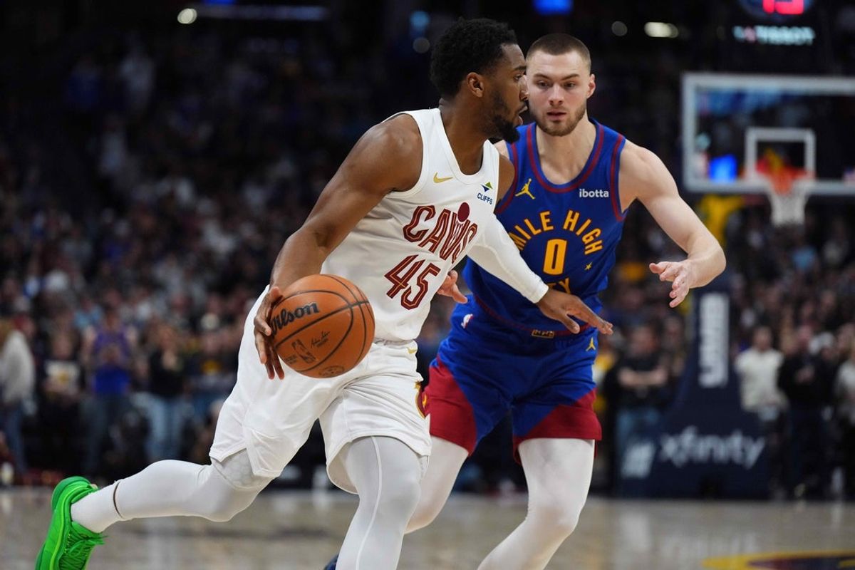 Feb 9, 2026; Denver, Colorado, USA; Cleveland Cavaliers guard Donovan Mitchell (45) dribbles past Denver Nuggets guard Christian Braun (0) in the first quarter at Ball Arena. Mandatory Credit: Ron Chenoy-Imagn Images