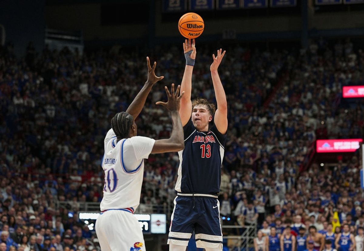 Feb 9, 2026; Lawrence, Kansas, USA; Arizona Wildcats center Motiejus Krivas (13) shoots against Kansas Jayhawks forward Flory Bidunga (40) during the first half at Allen Fieldhouse. Mandatory Credit: Jay Biggerstaff-Imagn Images