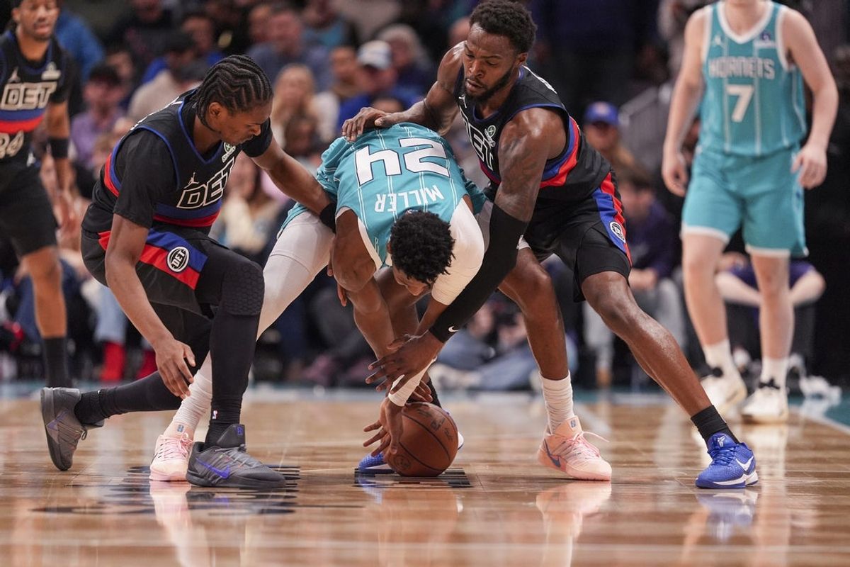 Feb 9, 2026; Charlotte, North Carolina, USA; Charlotte Hornets forward Brandon Miller (24) tries to hold the ball pressured by Detroit Pistons forward Paul Reed (7) and  guard/forward Ausar Thompson (9) during the second half at Spectrum Center. Mandatory Credit: Jim Dedmon-Imagn Images