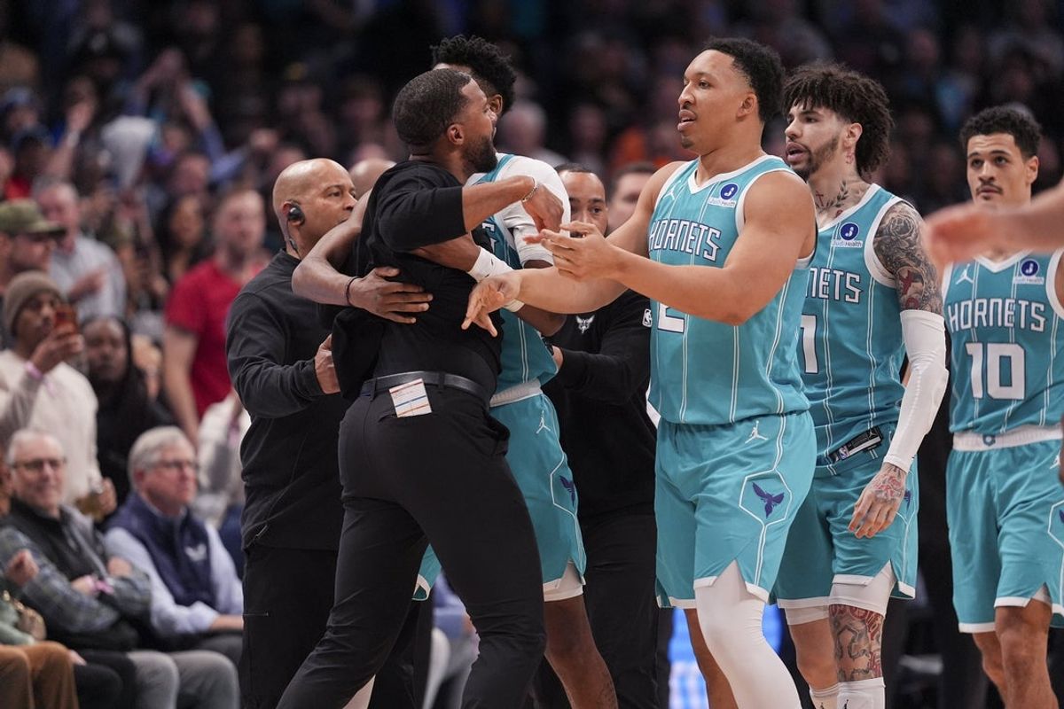 Feb 9, 2026; Charlotte, North Carolina, USA;  Charlotte Hornets forward Brandon Miller (24) and forward Grant Williams (2) hold back Head Coach Charles Lee after his ejection during the second half against the Detroit Pistons at Spectrum Center. Mandatory Credit: Jim Dedmon-Imagn Images
