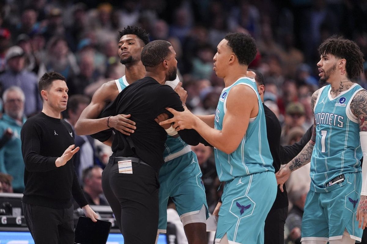 Feb 9, 2026; Charlotte, North Carolina, USA;  Charlotte Hornets forward Brandon Miller (24) and forward Grant Williams (2) hold back Head Coach Charles Lee after his ejection during the second half against the Detroit Pistons at Spectrum Center. Mandatory Credit: Jim Dedmon-Imagn Images
