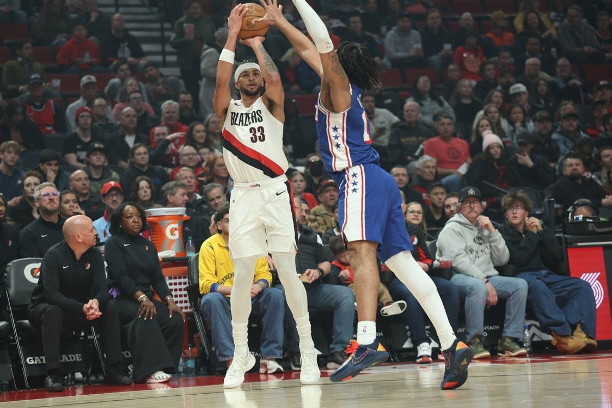 Feb 9, 2026; Portland, Oregon, USA;  Portland Trail Blazers forward Toumani Camara (33) shoots the ball over Philadelphia 76ers guard/forward Trendon Watford (12) during the first half at Moda Center. Mandatory Credit: Jaime Valdez-Imagn Images