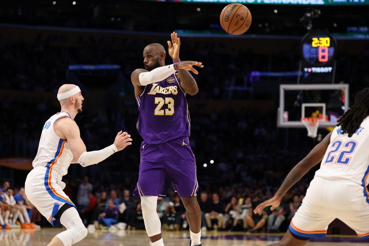 Feb 9, 2026; Los Angeles, California, USA;  Los Angeles Lakers forward LeBron James (23) passes the ball against Oklahoma City Thunder guard Alex Caruso (9) during the third quarter at Crypto.com Arena. Mandatory Credit: Kiyoshi Mio-Imagn Images
