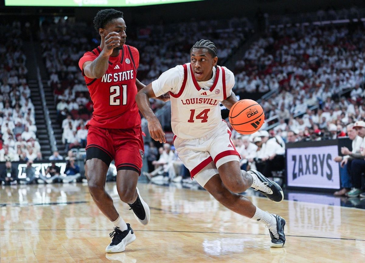 Louisville Cardinals guard Adrian Wooley (14) drives as NC State Wolfpack guard Terrance Arceneaux (21) defends during ACC basketball February 9, 2026 in Louisville, Kentucky.