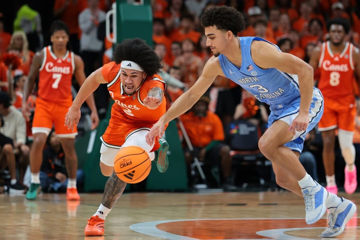Feb 10, 2026; Coral Gables, Florida, USA; Miami Hurricanes guard Tre Donaldson (3) and North Carolina Tar Heels guard Derek Dixon (3) reach for a loose ball during the first half at Watsco Center. Mandatory Credit: Sam Navarro-Imagn Images