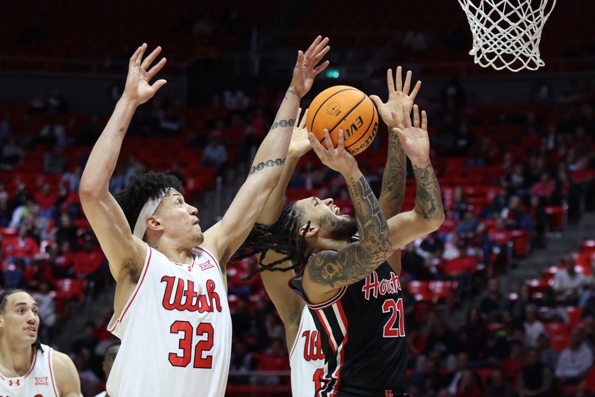 Feb 10, 2026; Salt Lake City, Utah, USA; Houston Cougars guard Emanuel Sharp (21) goes to the basket against Utah Utes forward James Okonkwo (32) during the first half at Jon M. Huntsman Center. Mandatory Credit: Rob Gray-Imagn Images