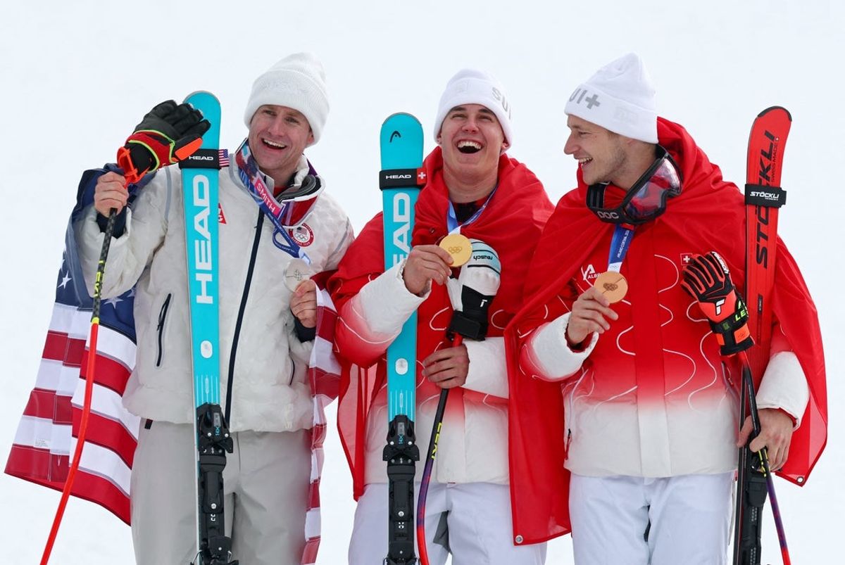 [US, Mexico & Canada customers only] Feb 11, 2026; Bormio, Italy; Gold medallist Franjo von Allmen of Switzerland celebrates on the podium with silver medallist Ryan Cochran-Siegle of United States and bronze medallist Marco Odermatt of Switzerland after the men's alpine skiing super G race during the Milano Cortina 2026 Olympic Winter Games at Stelvio Ski Centre. Mandatory Credit: Marko Djurica/Reuters via Imagn Images