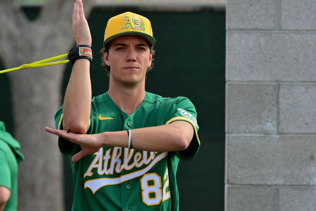 Feb 11, 2026; Mesa, AZ, USA;  Athletics pitcher Kade Morris (82) warms up during a Spring Training workout at HoHhokum stadium. Mandatory Credit: Matt Kartozian-Imagn Images