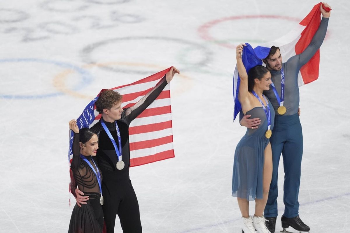 Feb 11, 2026; Milan, Italy; Silver medalists Madison Chock and Evan Bates of the United States and gold medalists Laurence Fournier Beaudry pose after receiving their medals during the Milano Cortina 2026 Olympic Winter Games at Milano Ice Skating Arena. Mandatory Credit: Amber Searls-Imagn Images