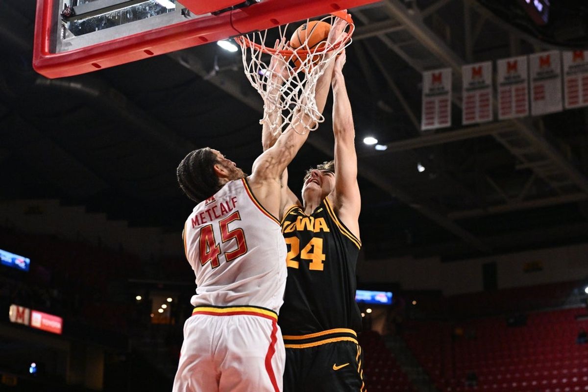 Feb 11, 2026; College Park, Maryland, USA;  Iowa Hawkeyes guard Tate Sage (#24) is fouled by Maryland Terrapins center Colin Metcalf (45) while attempting a lay in in the first half at Xfinity Center. Mandatory Credit: Jamie Sabau-Imagn Images