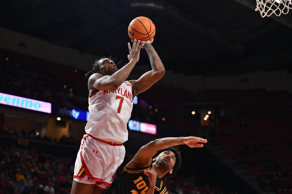 Feb 11, 2026; College Park, Maryland, USA;  Maryland Terrapins guard Andre Mills (7) puts back a rebound for two points over Iowa Hawkeyes guard Kael Combs (#11) in the second half at Xfinity Center. Mandatory Credit: Jamie Sabau-Imagn Images