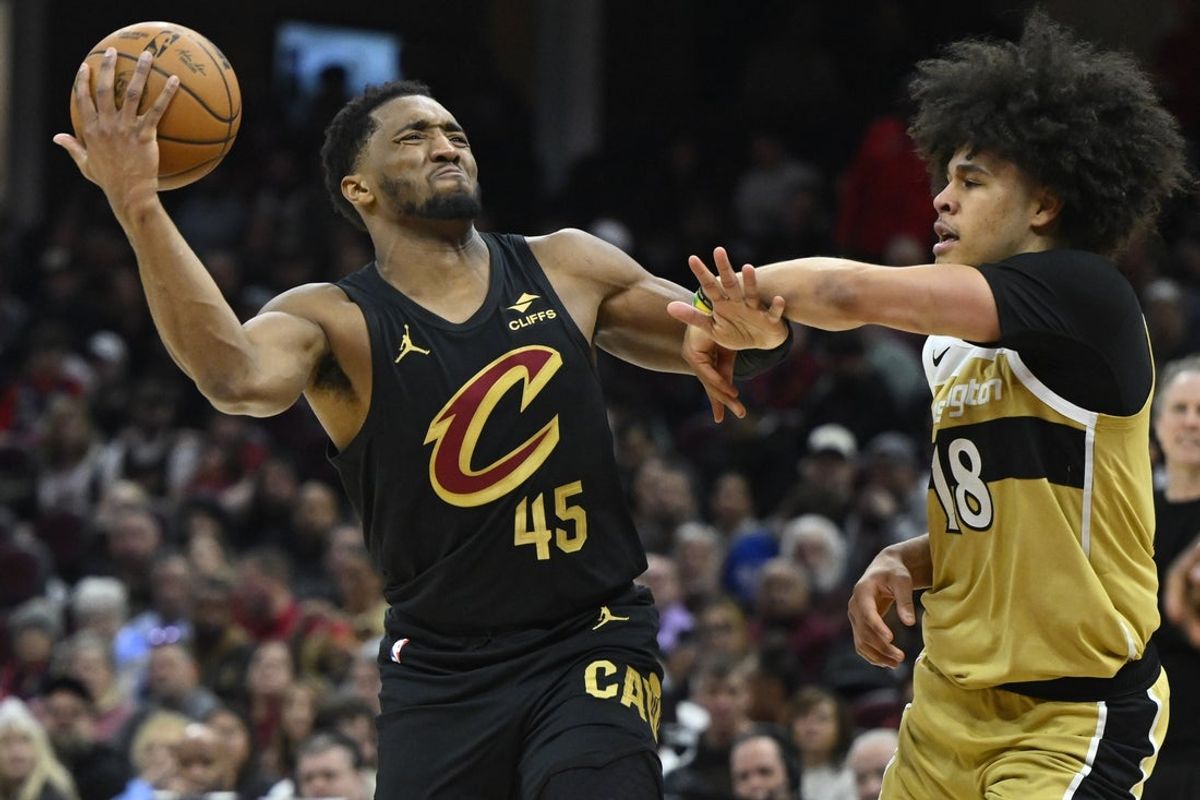 Feb 11, 2026; Cleveland, Ohio, USA; ICleveland Cavaliers guard Donovan Mitchell (45) drives to the basket beside Washington Wizards forward Kyshawn George (18) n the third quarter at Rocket Arena. Mandatory Credit: David Richard-Imagn Images