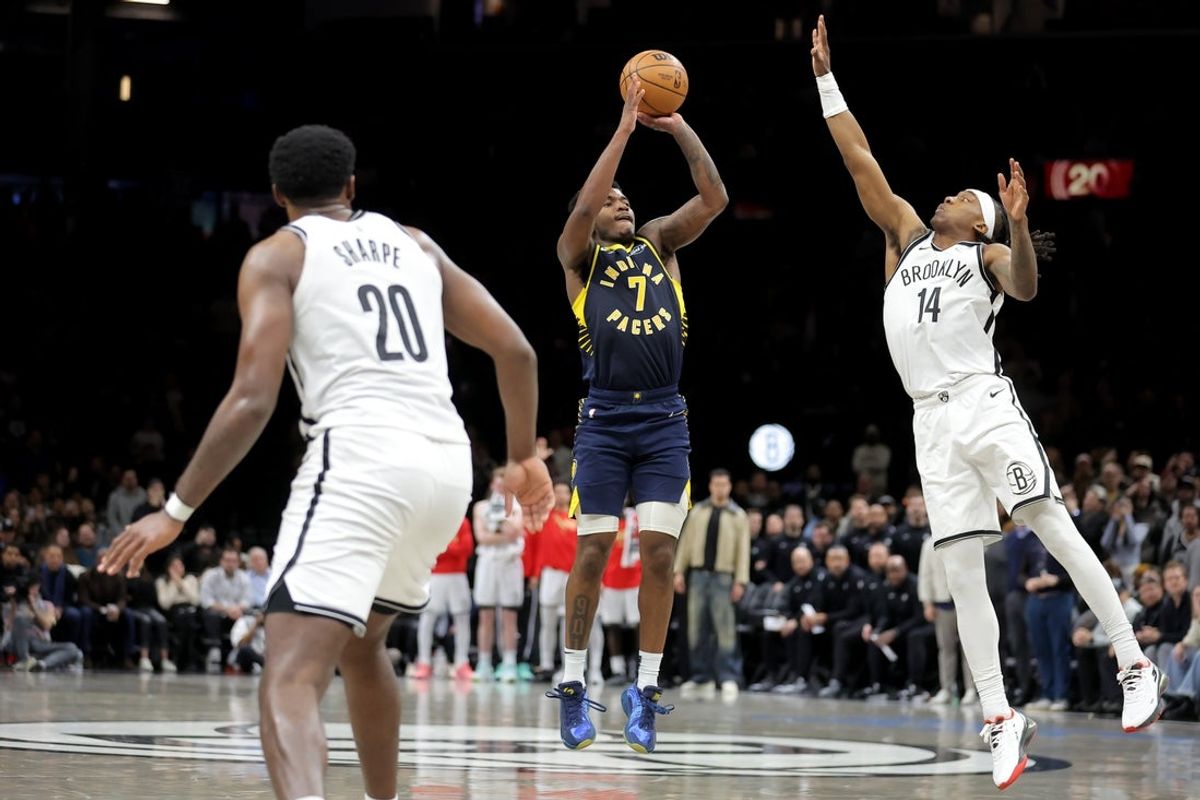 Feb 11, 2026; Brooklyn, New York, USA; Indiana Pacers guard Kam Jones (7) shoots the go-ahead three point shot against Brooklyn Nets guard Terance Mann (14) and center Day'ron Sharpe (20) during the fourth quarter at Barclays Center. Mandatory Credit: Brad Penner-Imagn Images