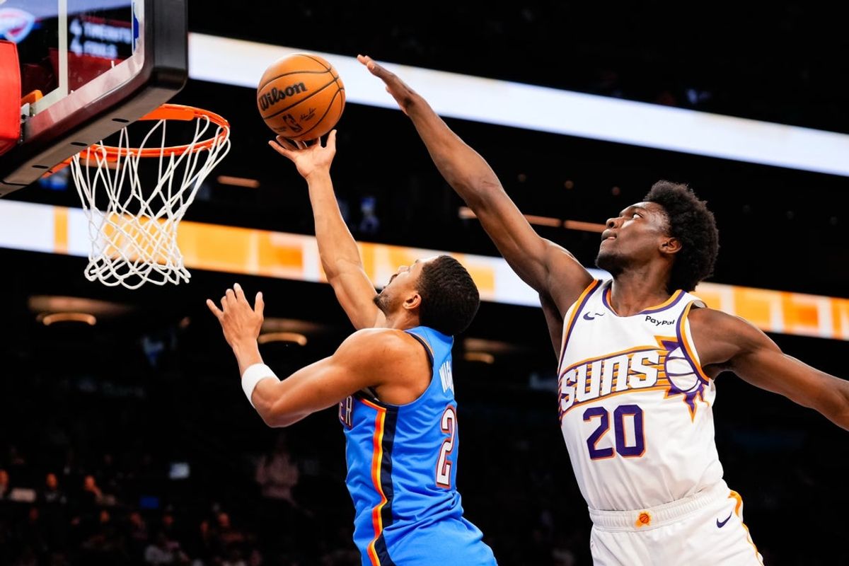 Feb 11, 2026; Phoenix, Arizona, USA; Oklahoma City Thunder guard Aaron Wiggins (21) goes for a shot against Phoenix Suns forward Rasheer Fleming (20) during the second half of the game at Mortgage Matchup Center. Mandatory Credit: Arianna Grainey-Imagn Images