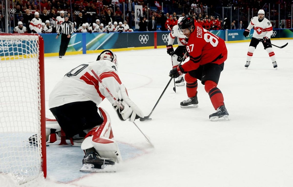 Feb 13, 2026; Milan, Italy; Sidney Crosby of Canada in action with Akira Schmid of Switzerland in men's ice hockey group A play during the Milano Cortina 2026 Olympic Winter Games at Milano Santagiulia Ice Hockey Arena. Mandatory Credit: Geoff Burke-Imagn Images