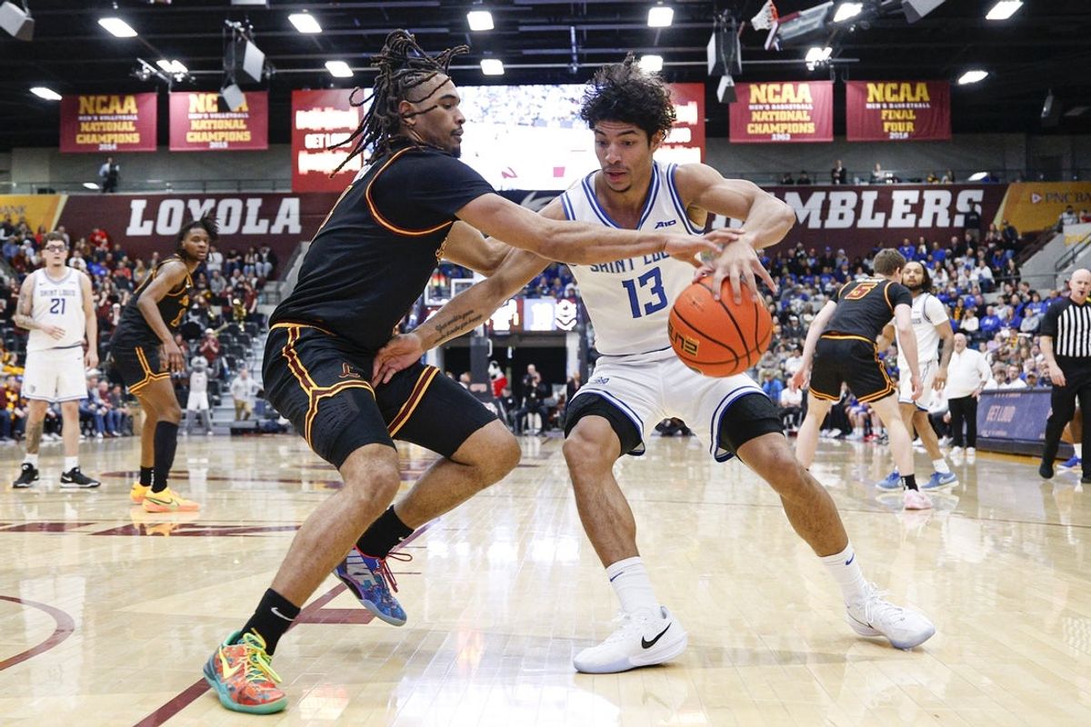Feb 13, 2026; Chicago, Illinois, USA; Loyola Chicago Ramblers guard Kayde Dotson (4) defends against Saint Louis Billikens guard Dion Brown (13) during the first half at Joseph J. Gentile Arena. Mandatory Credit: Kamil Krzaczynski-Imagn Images
