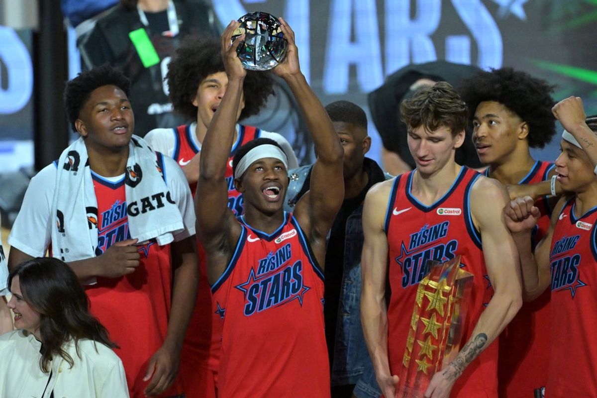 Feb 13, 2026; Inglewood, California, USA; Team Vince guard VJ Edgecombe (77) of the Philadelphia 76ers reacts with the MVP trophy after defeating Team Melo during an NBA All Star Rising Stars championship game at Intuit Dome. Mandatory Credit: Jayne Kamin-Oncea-Imagn Images