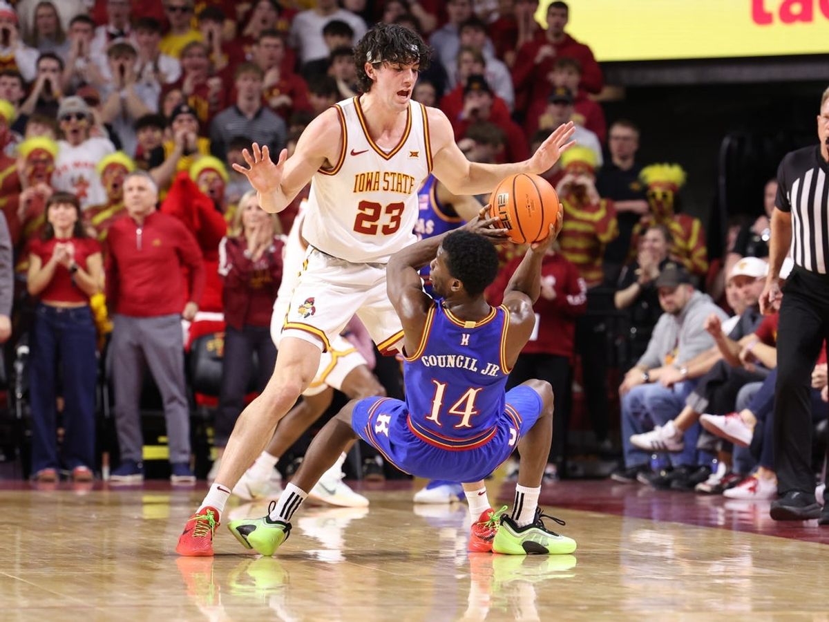 Feb 14, 2026; Ames, Iowa, USA; Iowa State Cyclones forward Blake Buchanan (23) defends Kansas Jayhawks guard Melvin Council Jr. (14) during the first half at James H. Hilton Coliseum. Mandatory Credit: Reese Strickland-Imagn Images
