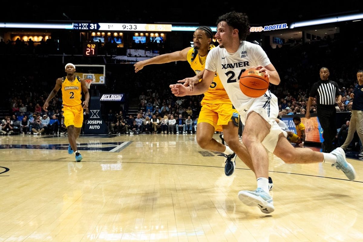 Xavier Musketeers forward Jovan Milicevic (24) drives on Marquette Golden Eagles forward Royce Parham (13) in the first half of the game at the Cintas Center in Cincinnati on Saturday, Feb. 14, 2026.