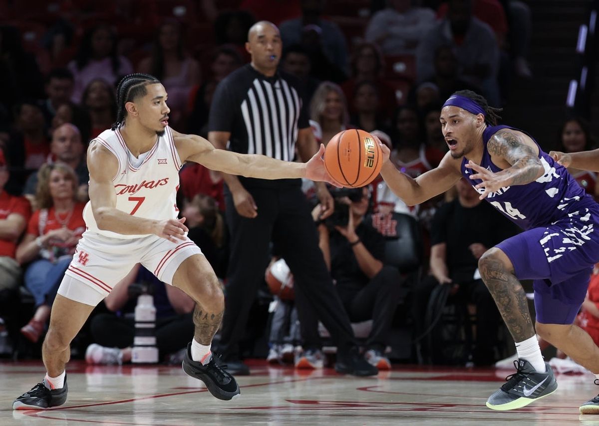 Feb 14, 2026; Houston, Texas, USA; Houston Cougars guard Milos Uzan (7) and Kansas State Wildcats guard Nate Johnson (34) reach for a loose ball  in the first half at Fertitta Center. Mandatory Credit: Thomas Shea-Imagn Images