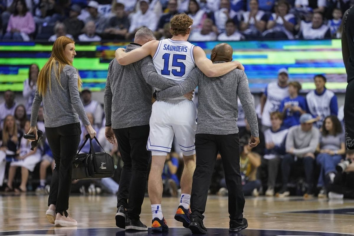Feb 14, 2026; Provo, Utah, USA; BYU Cougars guard Richie Saunders (15) is helped off the court after an injury during the first half against the Colorado Buffaloes at the Marriott Center. Mandatory Credit: Aaron Baker-Imagn Images