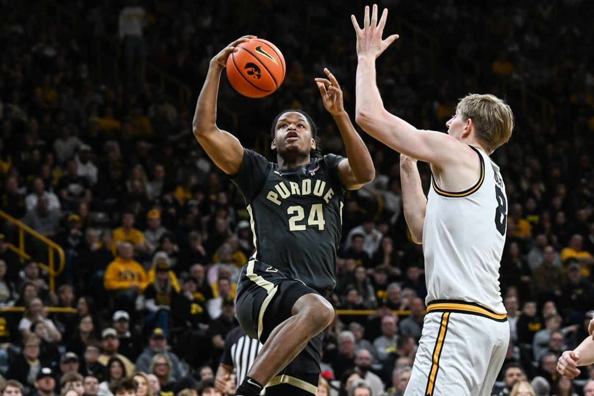 Feb 14, 2026; Iowa City, Iowa, USA; Purdue Boilermakers guard Gicarri Harris (24) goes to the basket as Iowa Hawkeyes forward Cooper Koch (8) defends during the first half at Carver-Hawkeye Arena. Mandatory Credit: Jeffrey Becker-Imagn Images