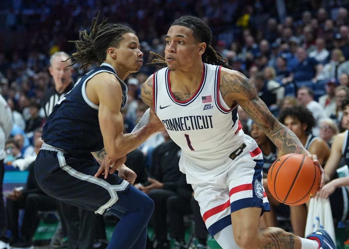 Feb 14, 2026; Storrs, Connecticut, USA; UConn Huskies guard Solo Ball (1) drives the ball against Georgetown Hoyas guard Malik Mack (2) in the first half at Harry A. Gampel Pavilion. Mandatory Credit: David Butler II-Imagn Images