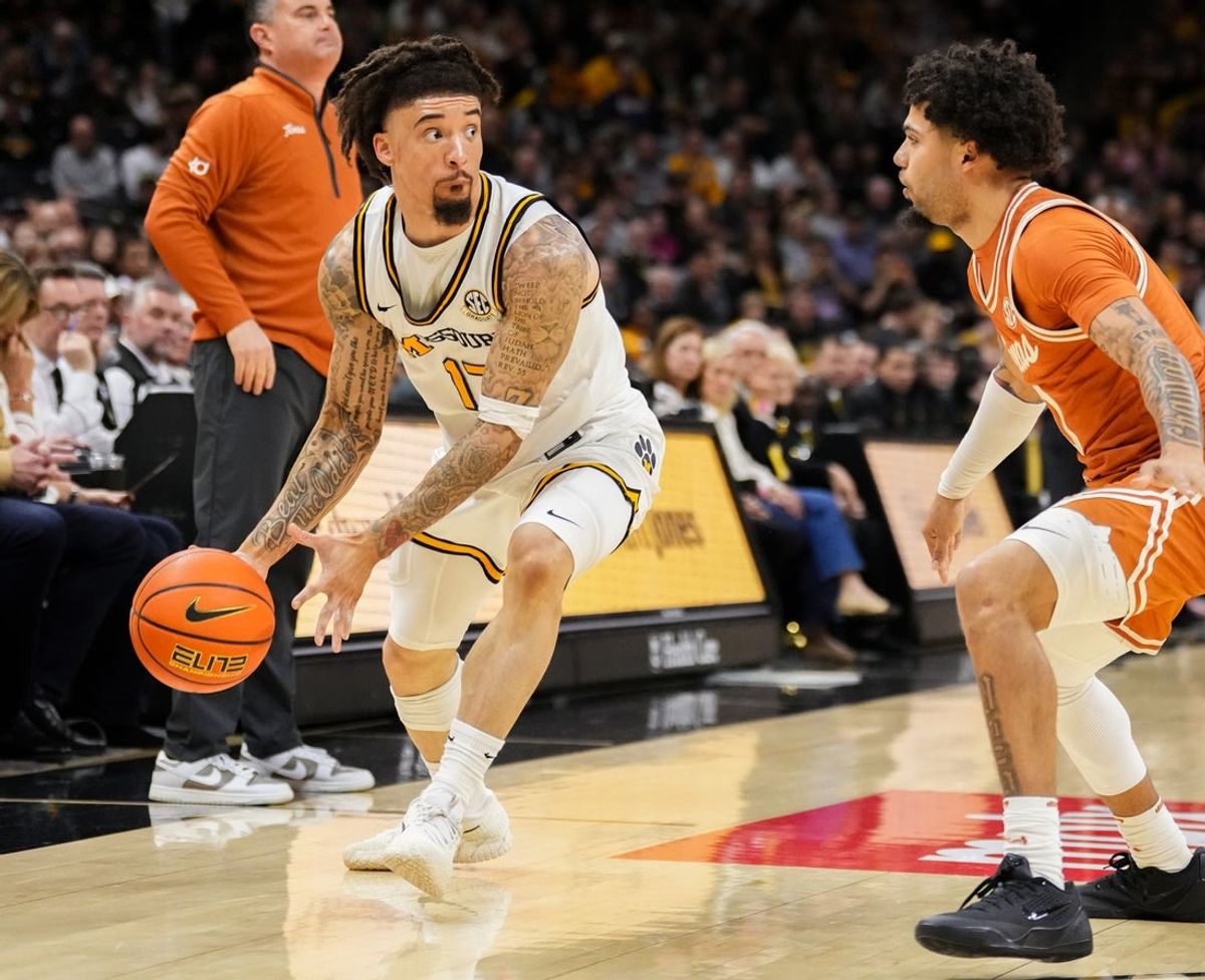 Feb 14, 2026; Columbia, Missouri, USA; Missouri Tigers forward Trent Pierce (11) dribbles the ball as Texas Longhorns forward Cole Bott (1) defends during the first half of the game at Mizzou Arena. Mandatory Credit: Denny Medley-Imagn Images
