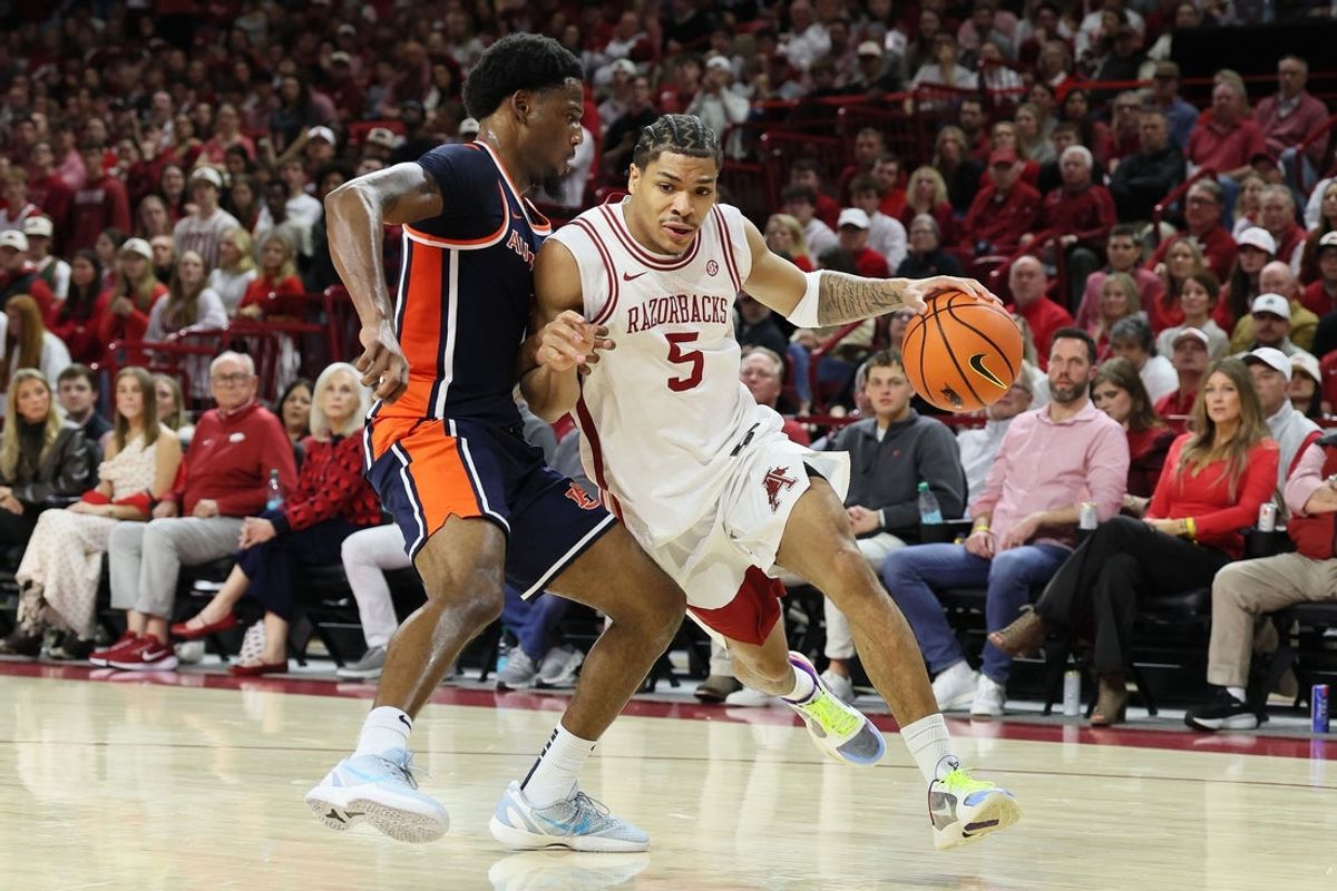 Feb 14, 2026; Fayetteville, Arkansas, USA; Arkansas Razorbacks guard Darius Acuff Jr (5) drives against an Auburn Tigers defender during the first half at Bud Walton Arena. Mandatory Credit: Nelson Chenault-Imagn Images