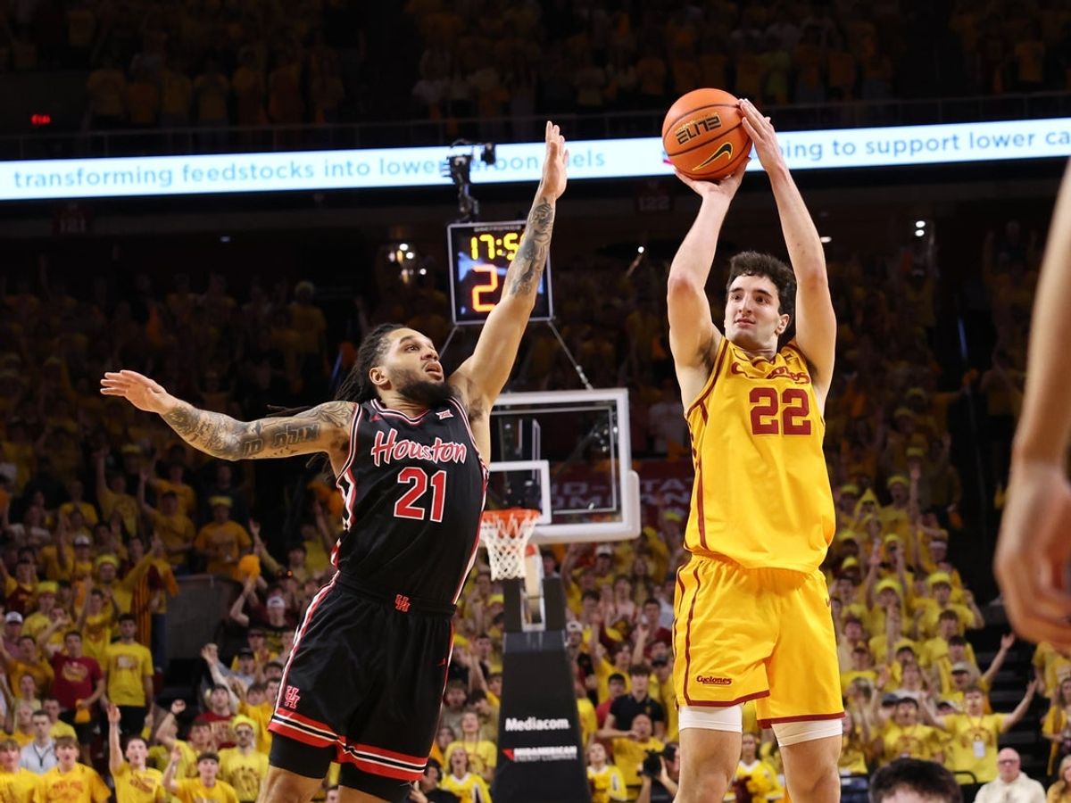 Feb 16, 2026; Ames, Iowa, USA; Houston Cougars guard Emanuel Sharp (21) defends Iowa State Cyclones forward Milan Momcilovic (22) during the first half at James H. Hilton Coliseum. Mandatory Credit: Reese Strickland-Imagn Images