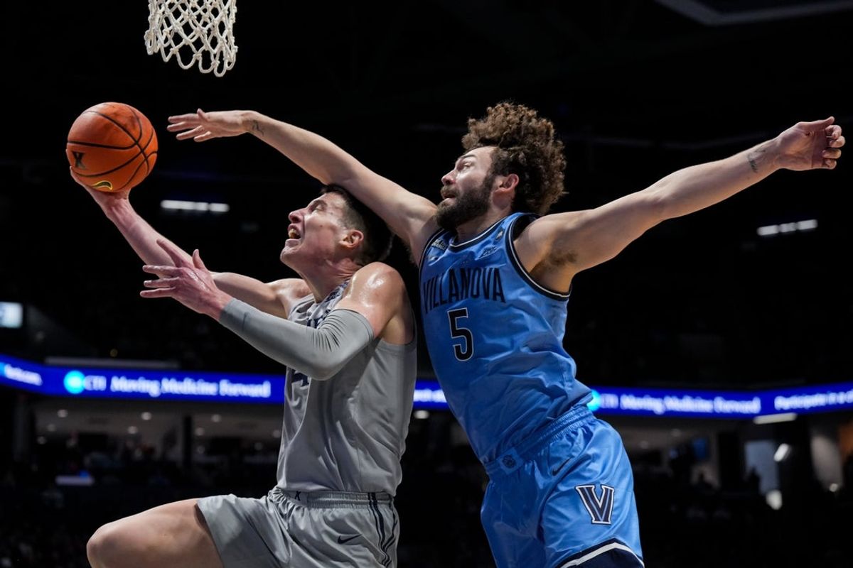 Feb 17, 2026; Cincinnati, Ohio, USA;  Xavier Musketeers forward Filip Borovicanin (4) drives to the basket as he is fouled by Villanova Wildcats guard Devin Askew (5) in the first half at the Cintas Center. Mandatory Credit: Aaron Doster-Imagn Images