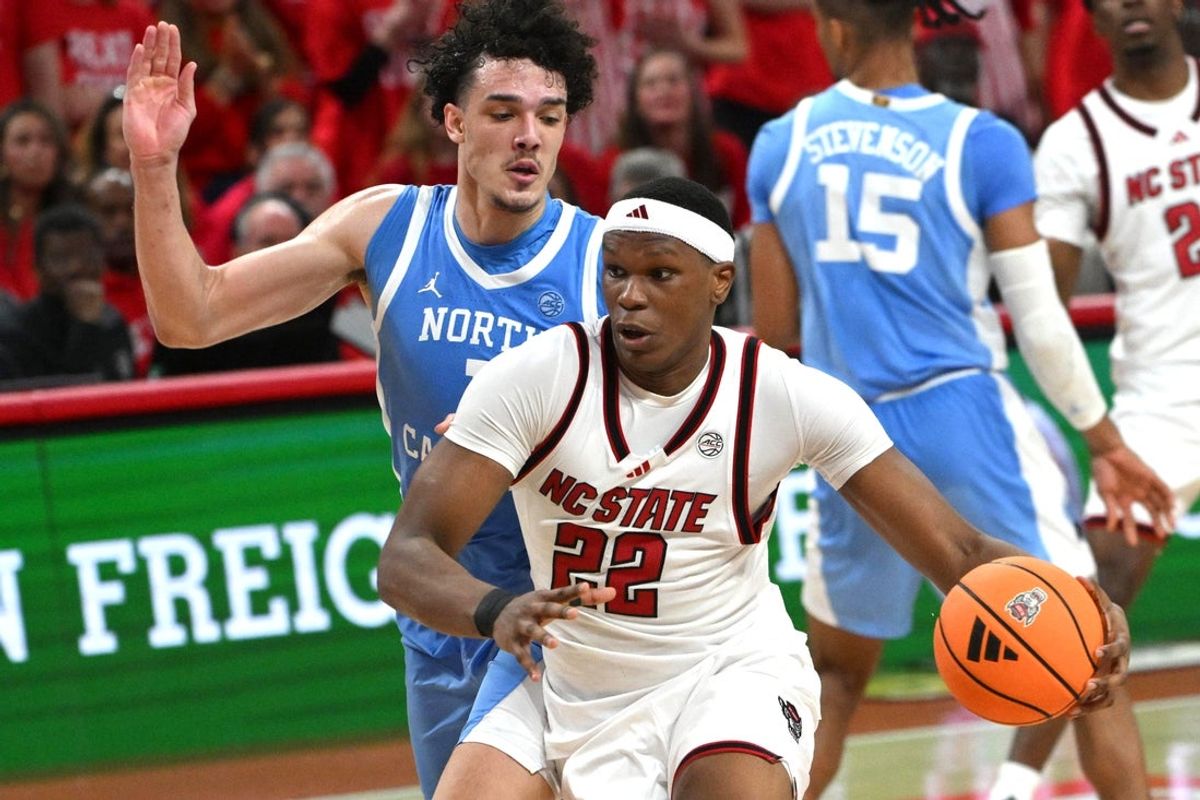 Feb 17, 2026; Raleigh, North Carolina, USA; NC State Wolfpack forward Ven-Allen Lubin (22) drives the ball to the basket against North Carolina Tar Heels forward Zayden High (1) during the first half at Lenovo Center. Mandatory Credit: Zachary Taft-Imagn Images