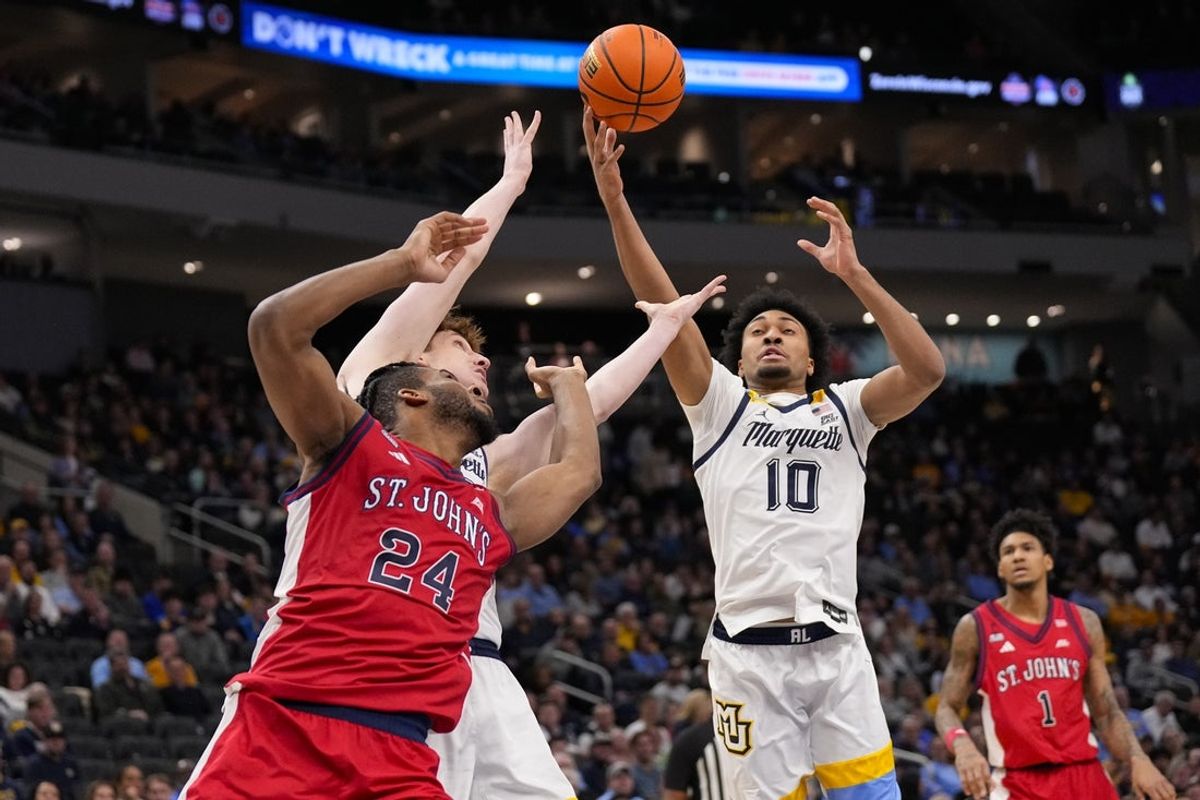 Feb 18, 2026; Milwaukee, Wisconsin, USA;  Marquette Golden Eagles guard Adrien Stevens (10) and St. John’s Red Storm forward Zuby Ejiofor (24) reach for the ball during the first half at Fiserv Forum. Mandatory Credit: Jeff Hanisch-Imagn Images