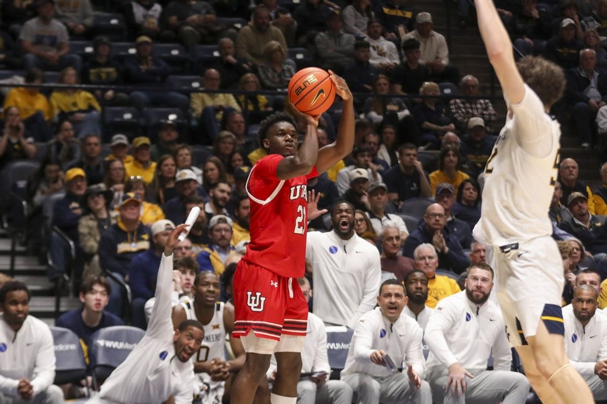 Feb 18, 2026; Morgantown, West Virginia, USA; Utah Utes guard Obomate Abbey (21) shoots a three pointer during the first half against the West Virginia Mountaineers at Hope Coliseum. Mandatory Credit: Ben Queen-Imagn Images