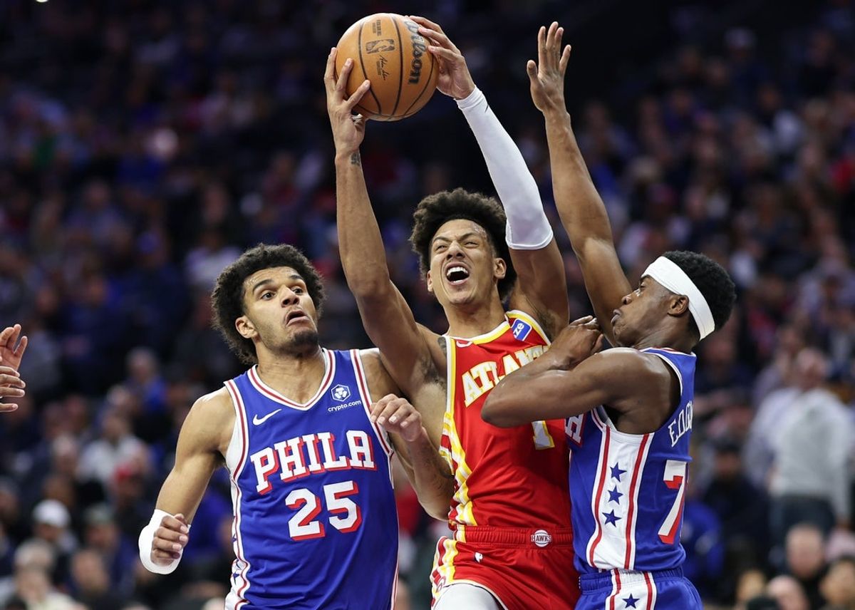 Feb 19, 2026; Philadelphia, Pennsylvania, USA; Atlanta Hawks forward Jalen Johnson (1) drives between Philadelphia 76ers guard Vj Edgecombe (77) and forward Dominick Barlow (25) during the first quarter at Xfinity Mobile Arena. Mandatory Credit: Bill Streicher-Imagn Images