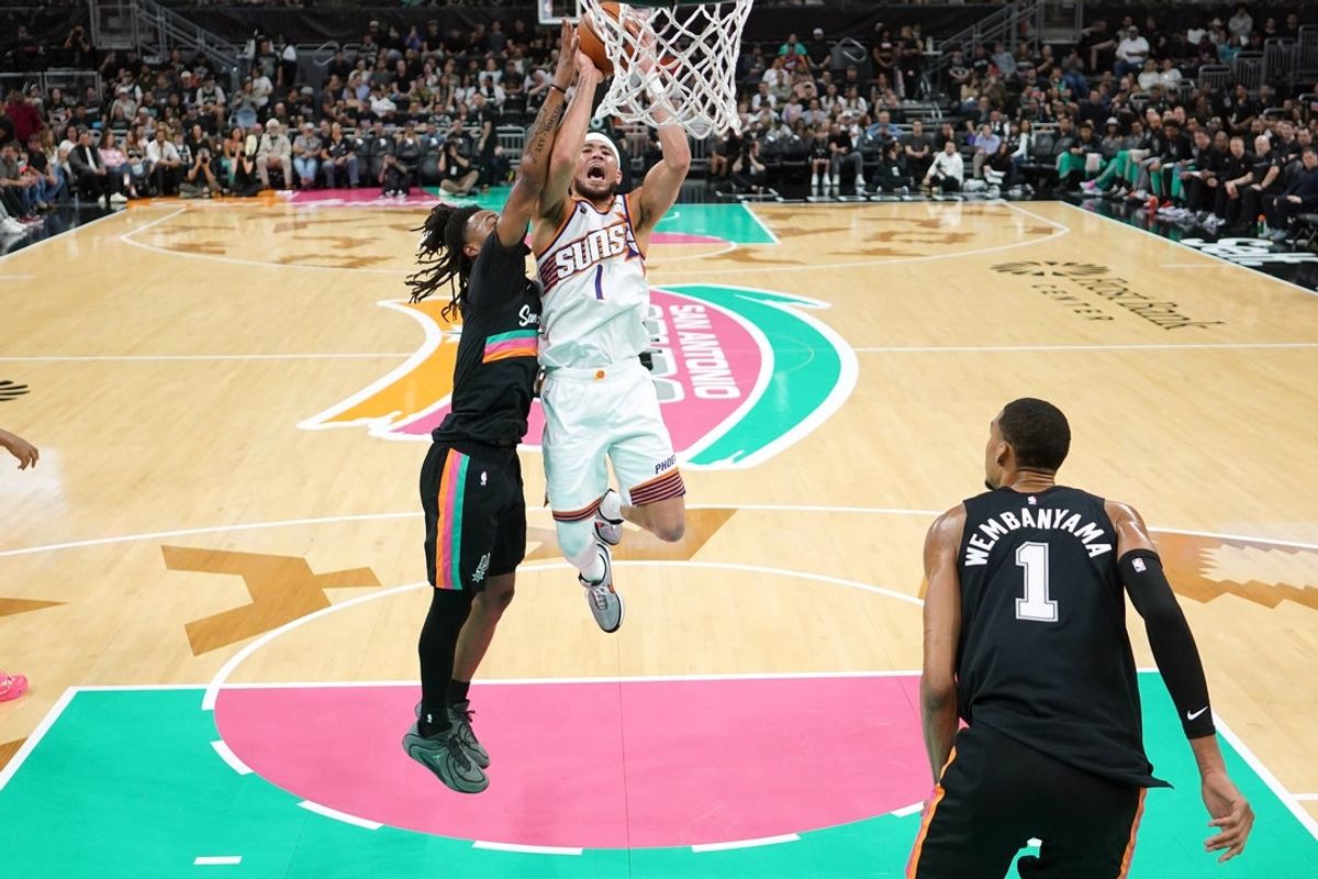 Feb 19, 2026; Austin, Texas, USA; Phoenix Suns guard Devin Booker (1) drives to the basket against San Antonio Spurs guard Stephon Castle (5) during the first half at Moody Center. Mandatory Credit: Scott Wachter-Imagn Images