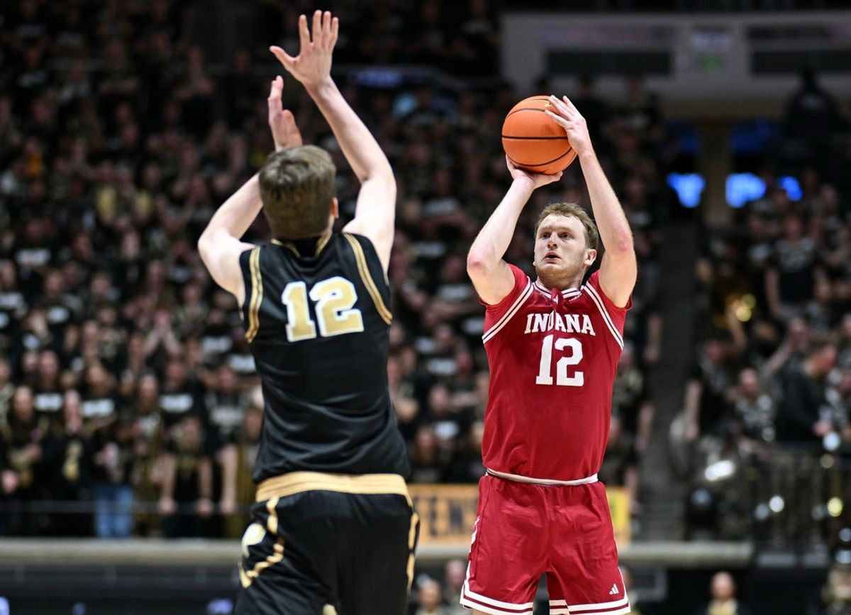 Feb 20, 2026; West Lafayette, Indiana, USA; Indiana Hoosiers forward Tucker Devries (12) shoots over Purdue Boilermakers center Daniel Jacobsen (12) during the first half at Mackey Arena. Mandatory Credit: Marc Lebryk-Imagn Images